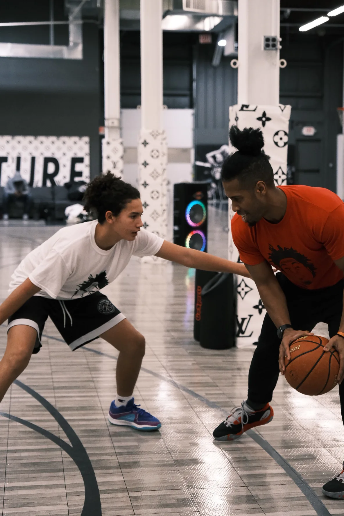Ben Allen coaching a young player in a defensive stance at Benjamin Buckets Training