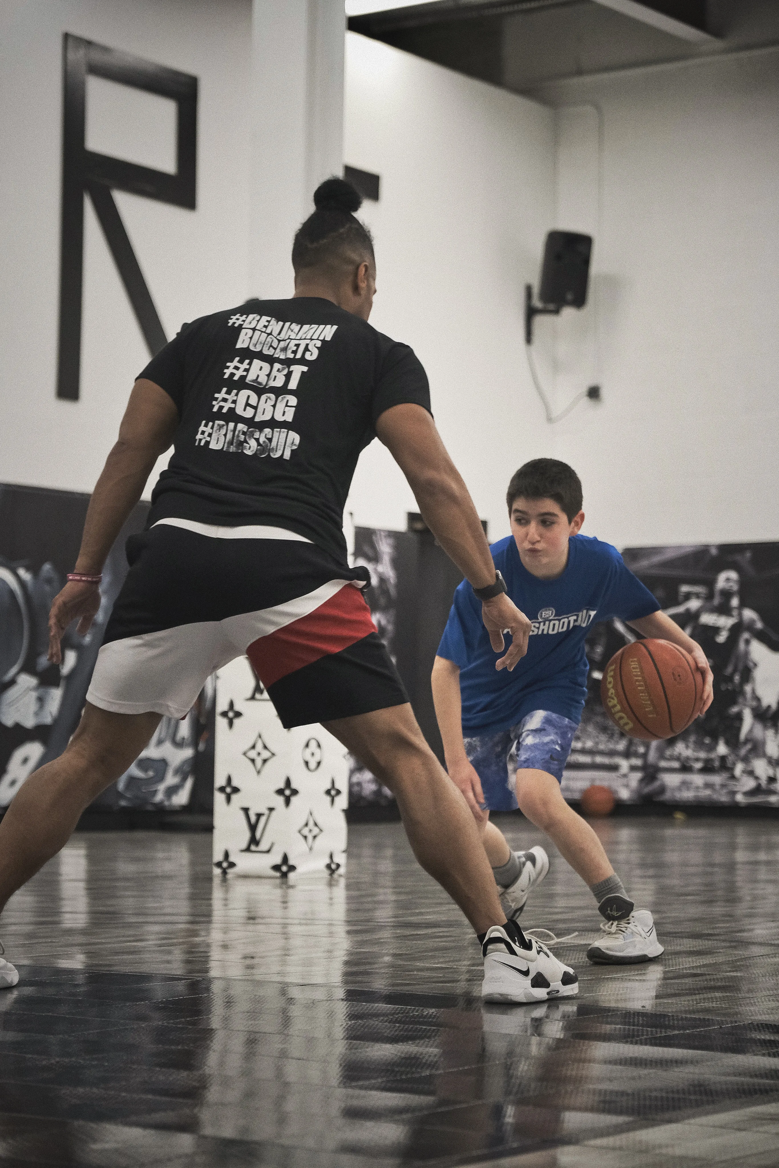 Ben Allen defending a young player in a blue shirt during training