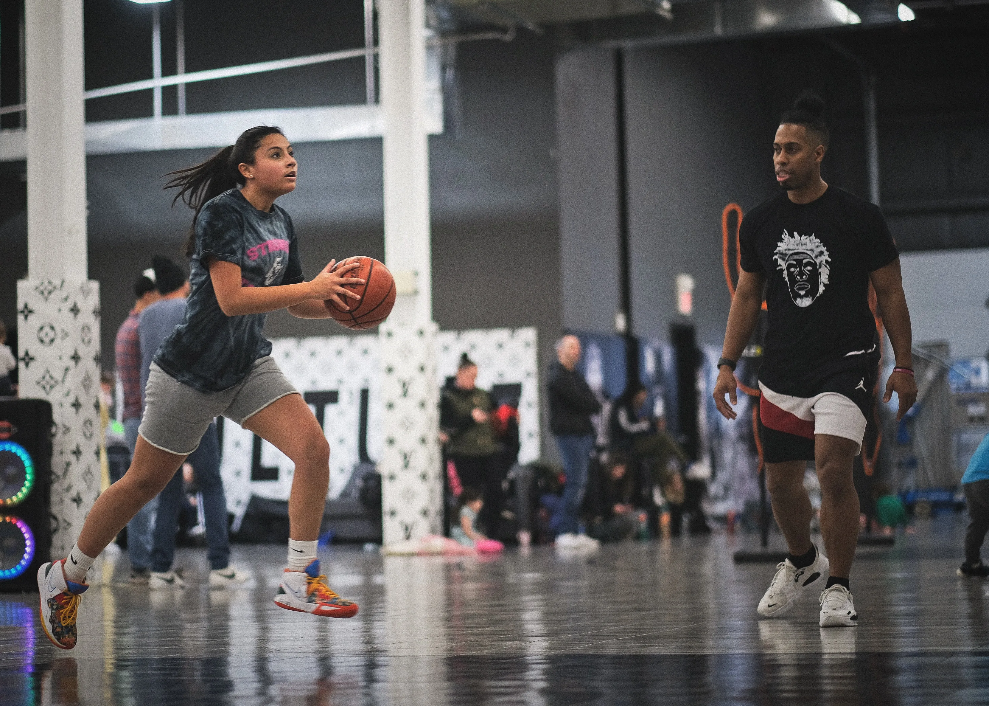 Ben Allen walking alongside a young player dribbling during training